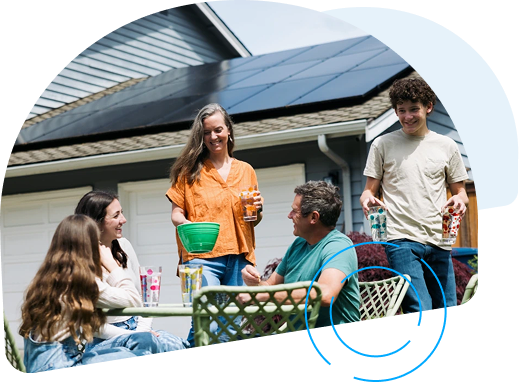 A father and his daughter holding a model house with solar panels on its roof.