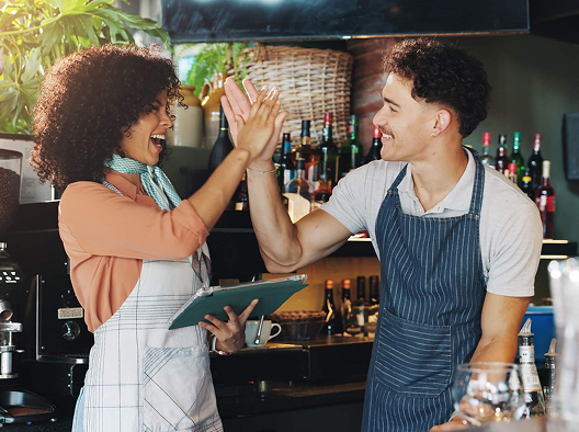 Two cafe workers high fiving