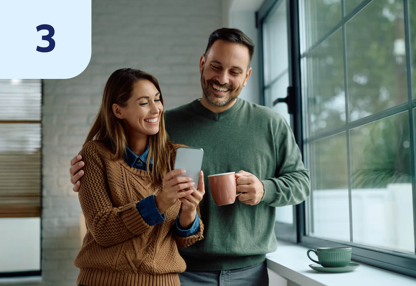 Two people standing together looking at a phone