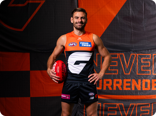A Greater Western Sydney Giants player runs with a ball on a football field.