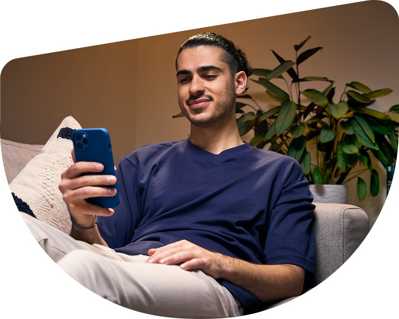 Man sitting on couch looking at his phone