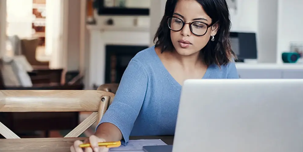 A woman working at her desk with a laptop.