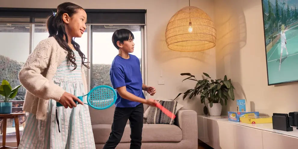 A sister and brother playing a video game together at home.