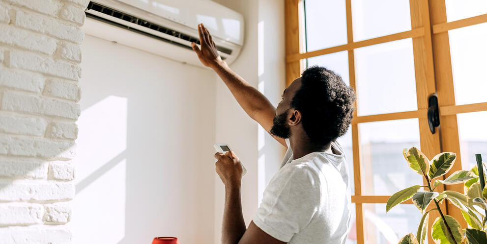 A man using his air conditioner at home.
