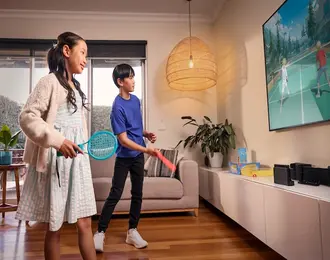 Two children are playing a video game together using a games console connected to the TV.