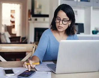 A woman working at her desk with a laptop.