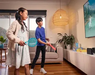 A sister and brother playing a video game together at home.