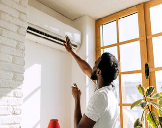 A man using his air conditioner at home.